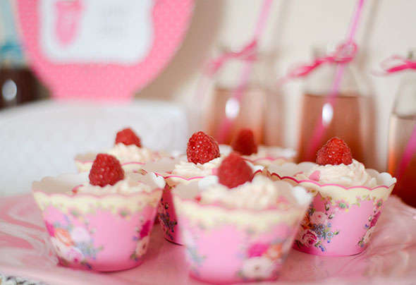 Muffins mit rosa Frosting und pinkroten Himbeeren