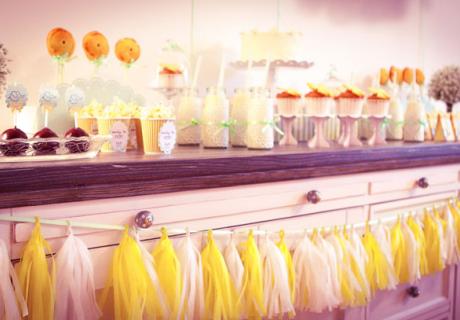 Eine selbstgebastelte Tasselgirlande in Gelb und Weiß für die neutrale Baby Shower